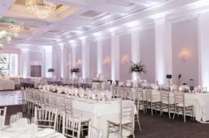 Elegant reception hall setup inside Ballroom at Ellis Preserve with long tables and chandelier lighting