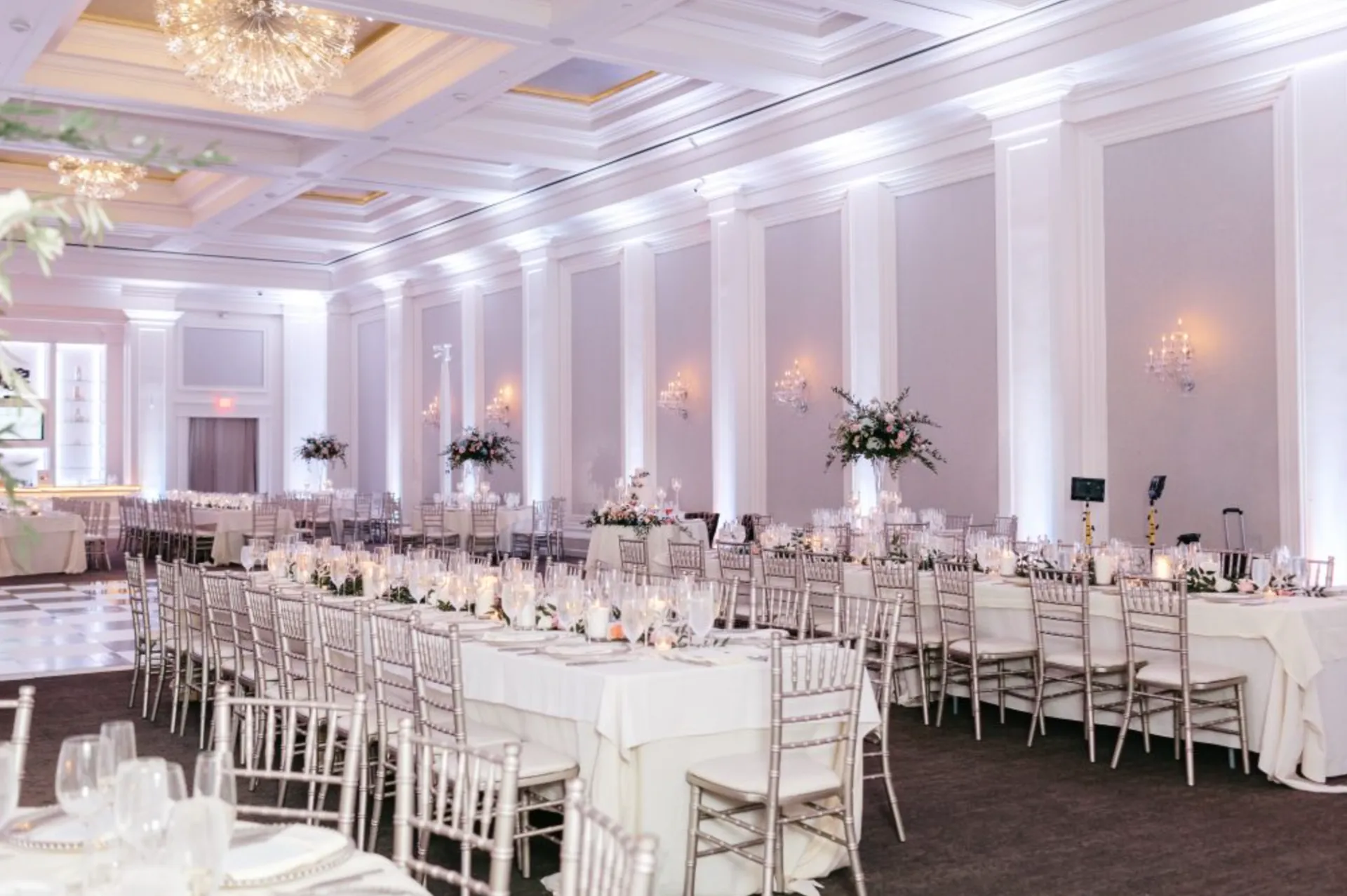 Long-table wedding dinner setup with uplighting at The Ballroom at Ellis Preserve