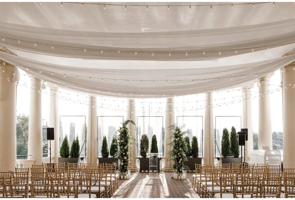 Wedding ceremony seating beneath draped fabric and columns at Water Works by Cescaphe